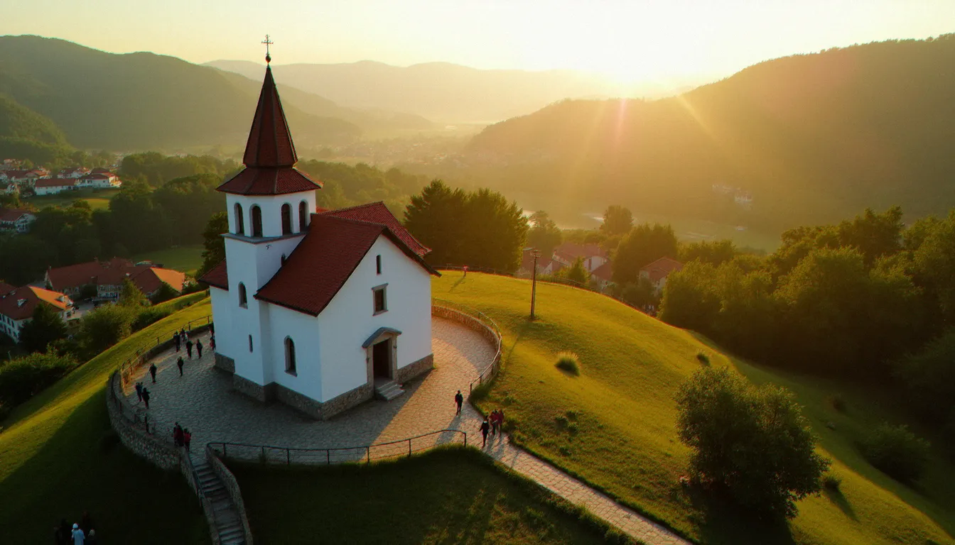 Vue aérienne du village de Medjugorje au coucher du soleil avec l'église Saint-Jacques et des pèlerins en route vers la colline des apparitions, lieu du pèlerinage marial en 2017